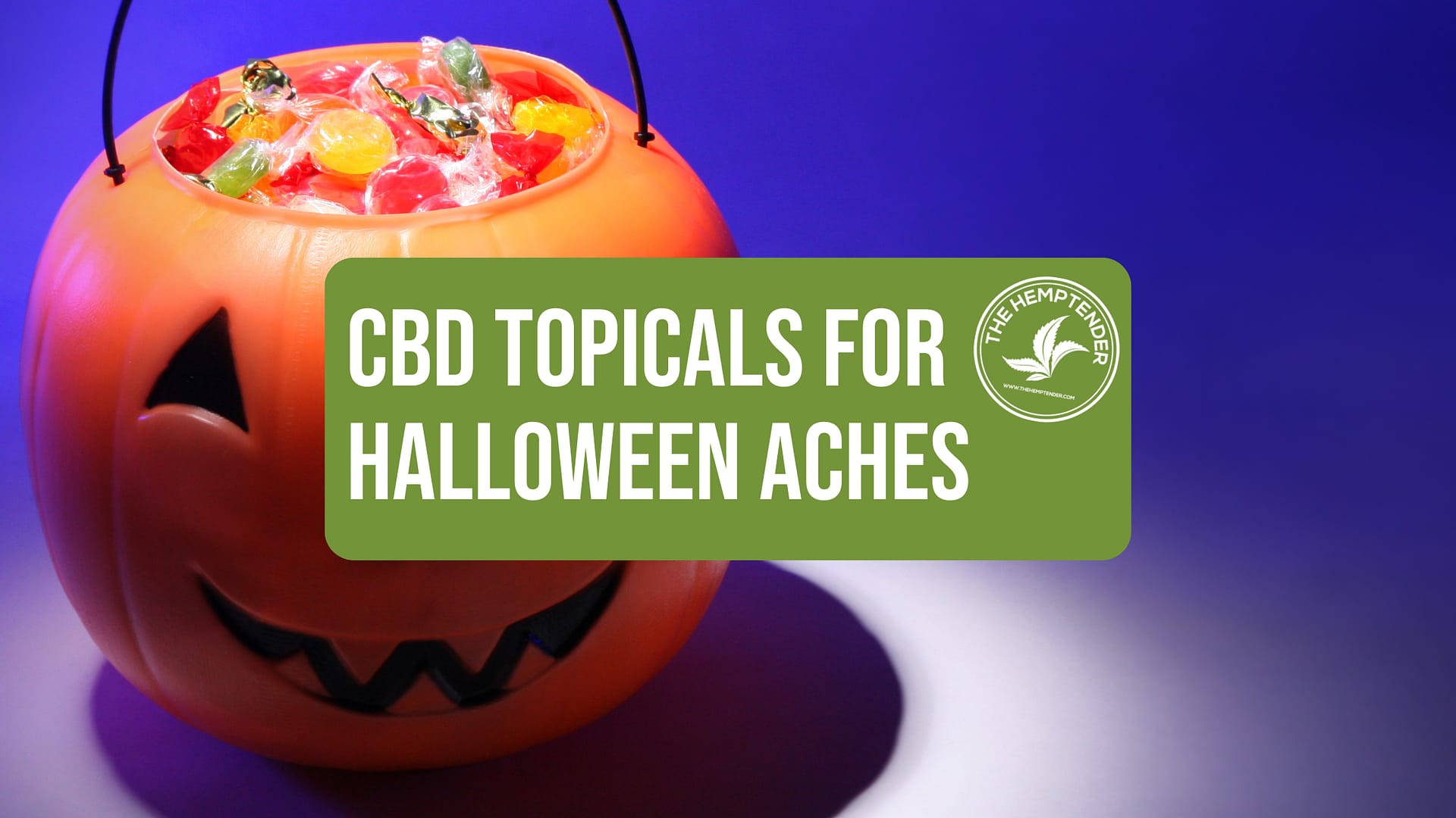 An orange pumpkin-shaped Halloween bucket filled with candy, with a green banner that reads 'CBD Topicals for Halloween Aches' featuring The Hemptender's logo.